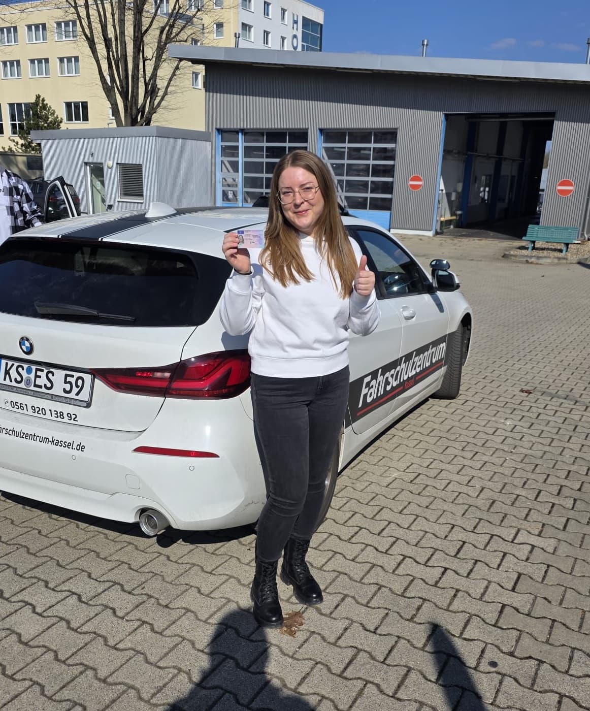 Alexandra mit ihrem Führerschein vor dem Fahrschulzentrum Kassel
